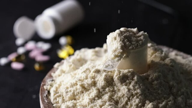 Pouring slow motion whey dry sport protein from above, supplements the food