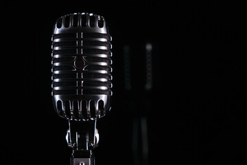 Studio metal retro microphone close-up on
black background with space for inscription