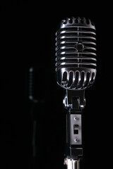 Studio metal retro microphone close-up on
black background with space for inscription