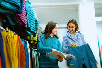 Young woman explores clothing options in a boutique with the help of a knowledgeable consultant