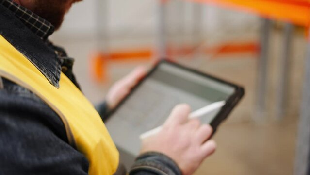 The quality manager engineer checks the constructed metalwork object for compliance with the 3D model in the tablet.