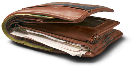 old worn out wallet with papers, receipts and cash inside, years of used broken and faded leather, frayed edges and scuffed surfaces, deteriorated men's practical accessory isolated white background