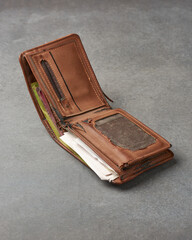 old worn out wallet with papers, receipts and cash inside, years of used broken and faded leather,...