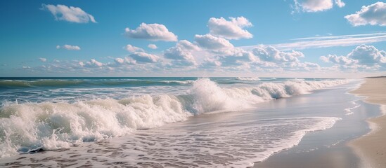 Obraz premium Picturesque Beach Landscape with Majestic Waves Crashing on the Sandy Shore in a Serene Coastal Scene