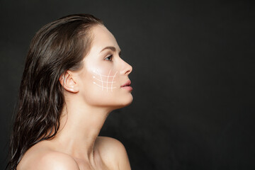 Lovely woman with massage or surgery lines on her face. Medicine, cosmetology and facial treatment...