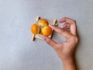 Hand holding Pineapple Cookies called Kue Nenas or Nastar in Indonesian, is one of the most popular...