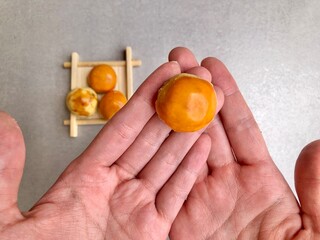 Hand holding Pineapple Cookies called Kue Nenas or Nastar in Indonesian, is one of the most popular traditional sweets to celebrate Eid al-Fitri. Selective focus.