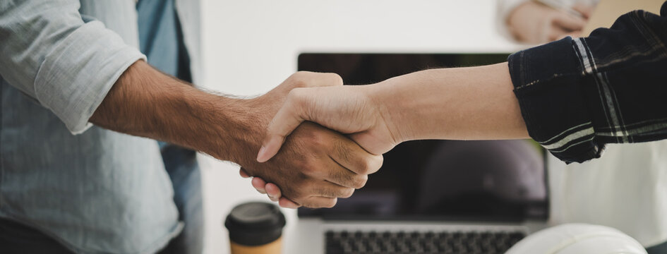 construction worker and contractor. Client shaking hands with team builder in renovation site.