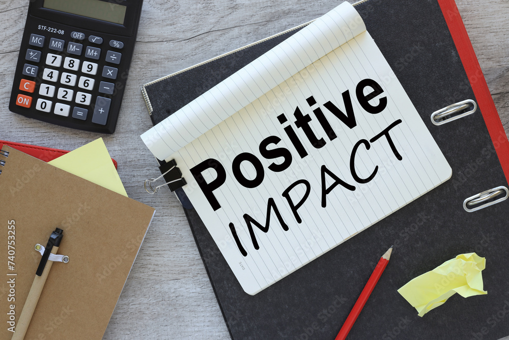 Poster positive impact text on notepad page. view from above