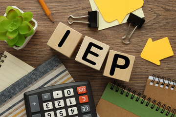 IEP three wooden blocks. text on wooden cubes. near the calculator