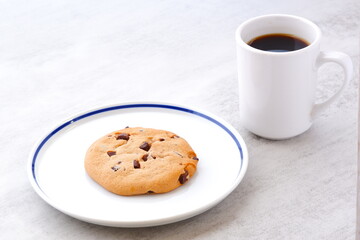 チョコレートがたっぷり入ったチョコチップクッキーとコーヒーでおやつの時間
