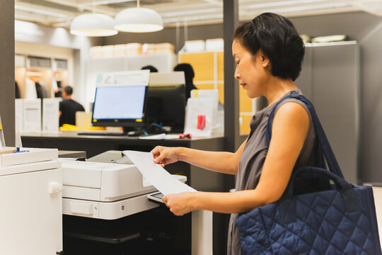 Businesswoman prints on the printer in the office.