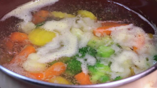 Boiling vegetarian soup with vegetables. Healthy diet food. Close up. 4k footage.