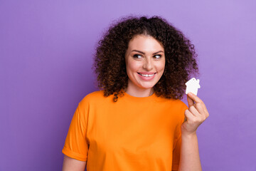 Photo of dreamy tricky lady dressed orange t-shirt rising little house looking empty space isolated violet color background