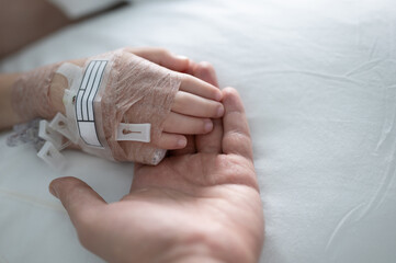 Adult hand hold kid palm in hospital