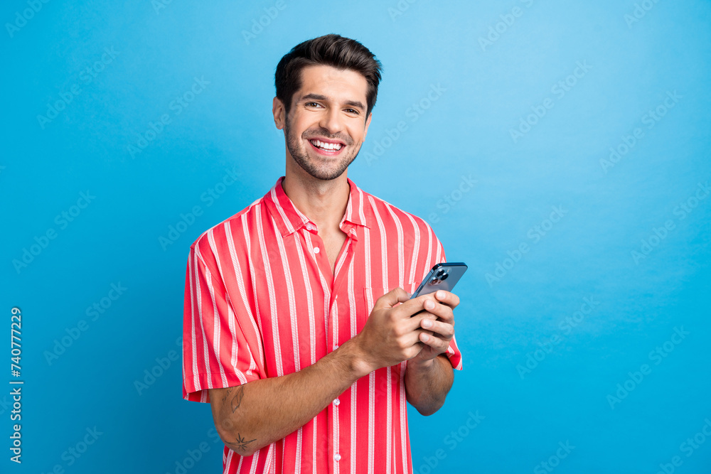 Canvas Prints Photo of excited cheerful man dressed striped shirt chatting instagram twitter telegram facebook empty space isolated blue color background