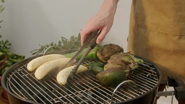 Grilled Banana on fire, latin american vegan grill with avocado and pepper, thai or Ecuadorian Street food. African traditional food on grill. 