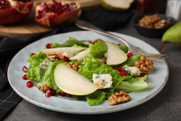 Delicious pear salad on dark textured table, closeup