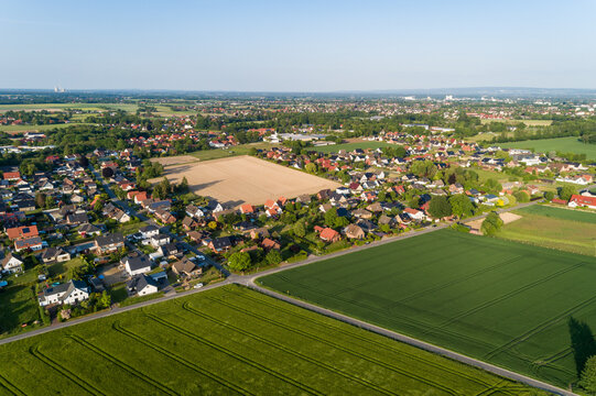 Luftaufnahme von Feldern mit einer Kleinstadt im Hintergrund