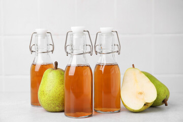 Tasty kombucha and pears on white table
