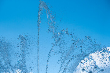 A high jet of a fountain with water on the background of the sky.