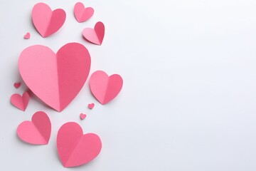 Pink paper hearts on white background, flat lay. Space for text