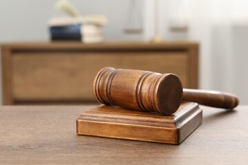 Wooden gavel and sound block on table indoors, closeup. Space for text