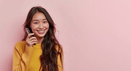 Fototapeta premium Asian girl using smartphone isolated on pink background with copy space for your text