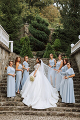 Wedding photography. A brunette bride in a white dress with a bouquet and her brunette girlfriends