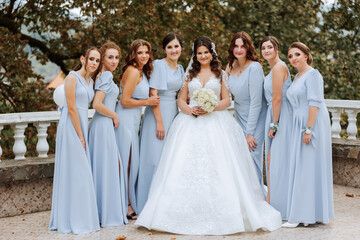 Wedding photography. A brunette bride in a white dress with a bouquet and her brunette girlfriends