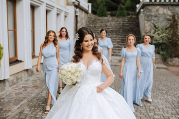 Wedding photography. A brunette bride in a white dress with a bouquet and her brunette girlfriends