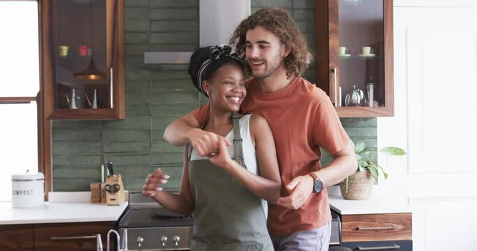 Diverse couple enjoys a cozy moment in the kitchen