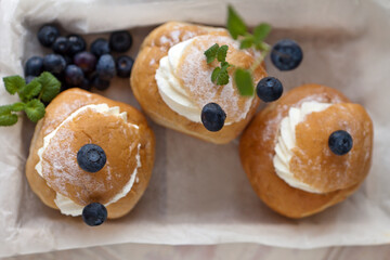 Top View of three Semla Cakes on wooden box with berries. semla top view from above