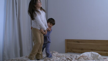 Children Jumping on Bed in Super Slow Motion, Captured at 800 fps, siblings bonding together while...