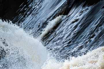 close up of flowing water, rapid water splashes of an white water river or stream, bubbly water