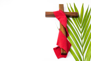 Jesus Wooden cross wrapped with red cloth with palm leaves. Catholic Christians Good Friday Ceremony. Isolated on white background with empty blank copy text space. - obrazy, fototapety, plakaty