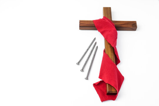Jesus Wooden cross wrapped with red cloth next to nails. Catholic Christians Good Friday Ceremony. Isolated on white background with empty blank copy text space.