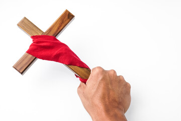 Someone hand holding Jesus Wooden cross wrapped with red cloth. Catholic Christians Good Friday...