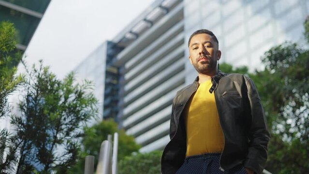 Portrait of serious queer man at city urban background. Confident genderqueer lgbt black man
