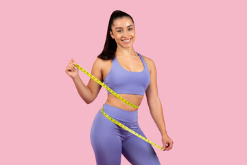 Sporty woman with measuring tape around waist
