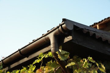Rain gutter system with drainpipe on house outdoors, low angle view - obrazy, fototapety, plakaty