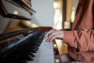 Hands of woman practicing music skills playing piano at home. Talented pianist enjoying melody....