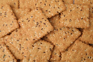 Cereal crackers with flax and sesame seeds as background, top view