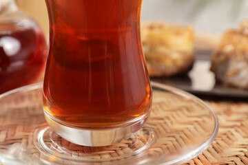 Traditional Turkish tea in glass on wicker table, closeup