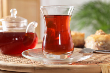 Traditional Turkish tea in glass on wicker table, closeup