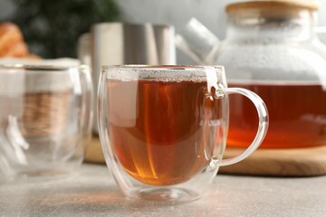 Aromatic tea in glass cup on light grey table