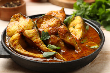 Tasty fish curry on white wooden table, closeup. Indian cuisine - obrazy, fototapety, plakaty