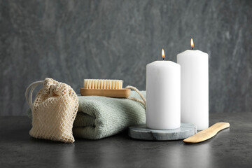 Fototapeta na wymiar Composition with different spa products and burning candles on grey table