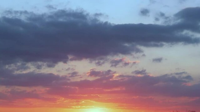 Colorful Dramatic Orange Blue Skyscraper at Sunset Clouds and Sun Sets Time Lapse. Beautiful Evning Sky and Colored Clouds Timelapse. Multicolored Background Evening Sunset Firmament.