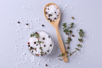 Salt with peppercorns in bowl, spoon and thyme on light table, flat lay